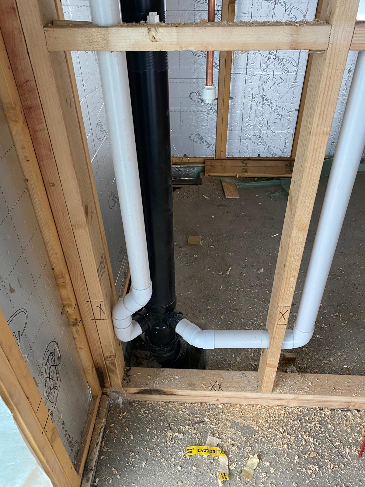 Soil stack with solvent weld branch waste connections running through studwork