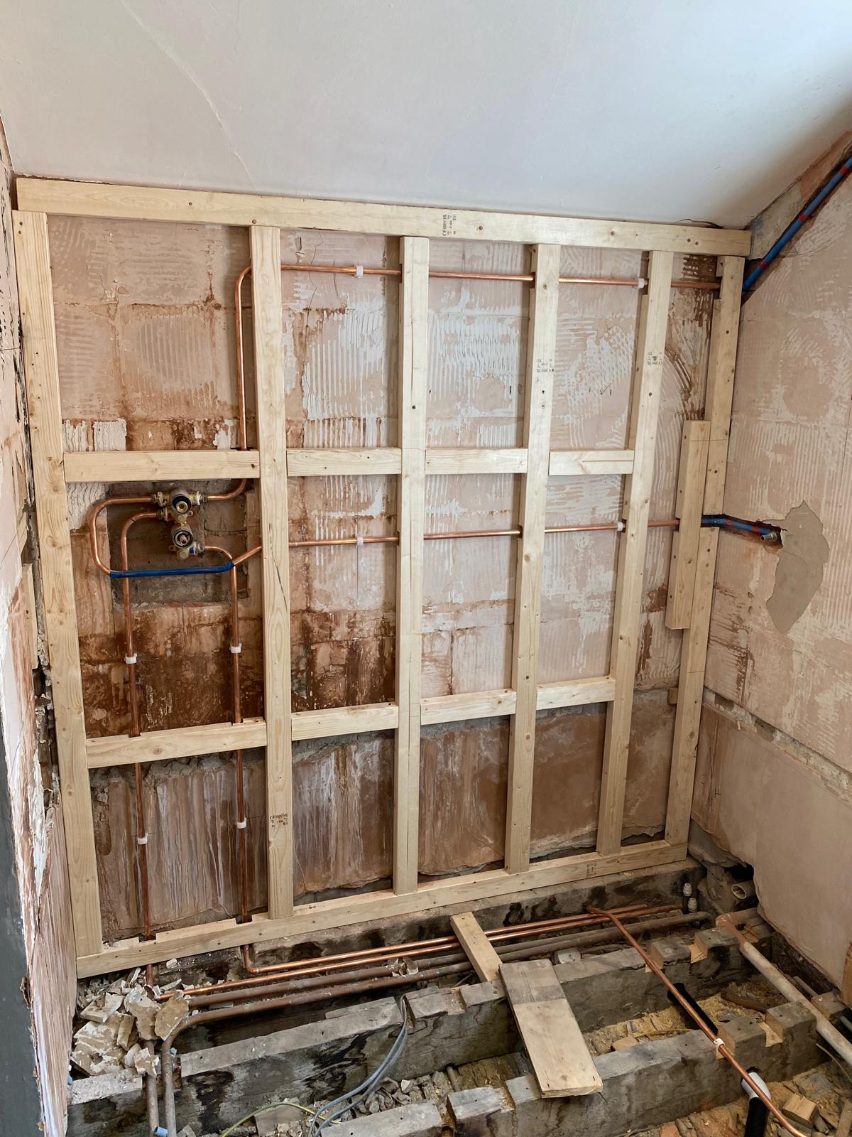 Shower corner stripped back to brick with new timber stud framing and copper pipework