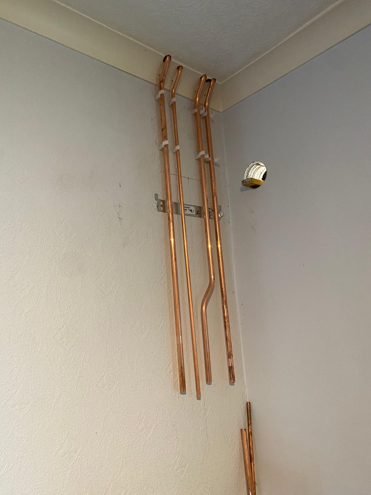 Capped copper boiler tails clipped to the wall ready for the boiler to be hung