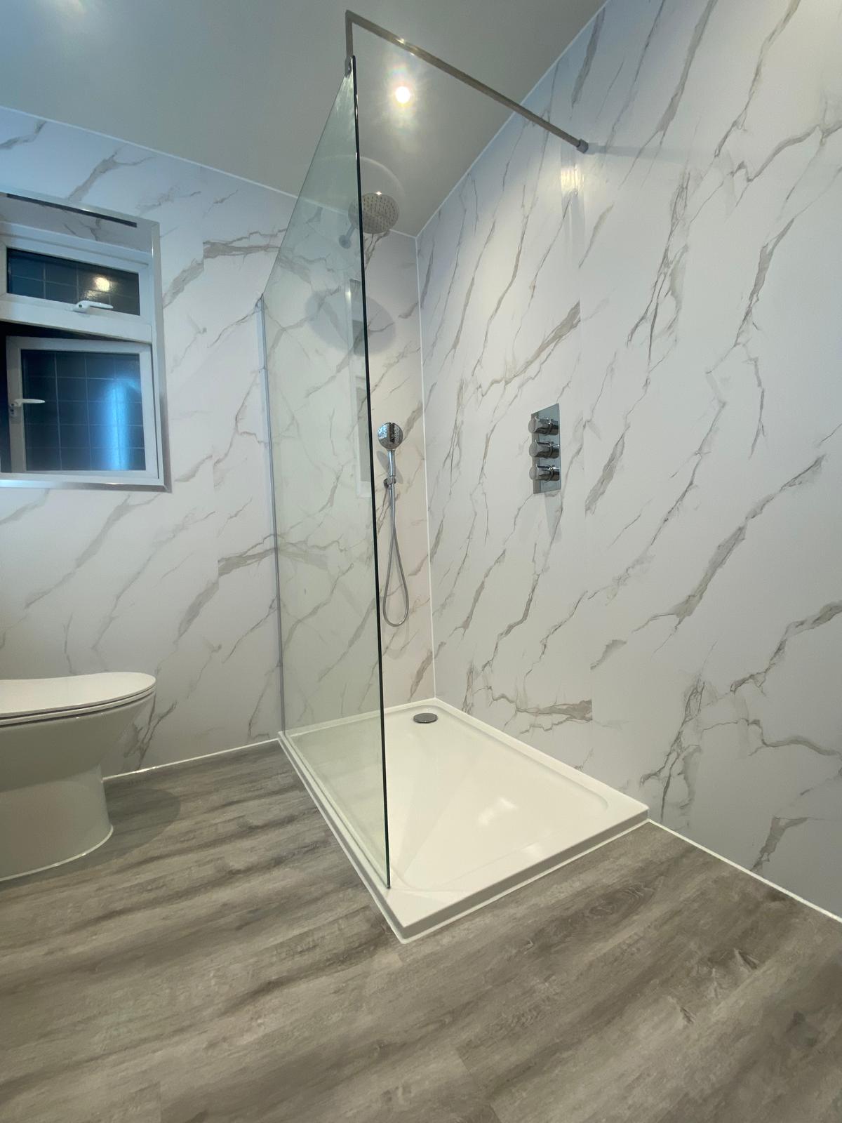 Walk-in shower with glass screen, rainfall head and marble effect wall panels