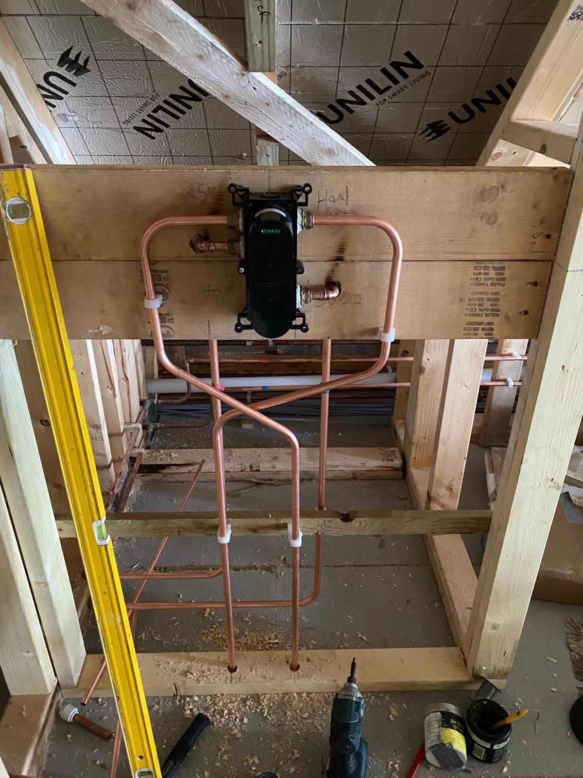 Concealed shower valve mounted level on a timber carrier with copper feeds and outlets