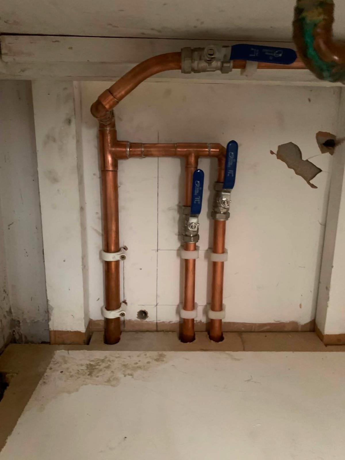 Finished copper manifold with blue handled isolation valves for the new hot water circuit
