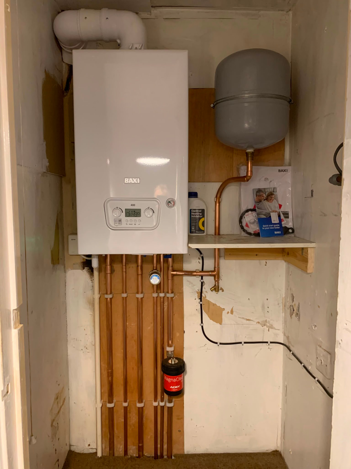 New boiler and expansion vessel with fresh copper pipework on a plywood board