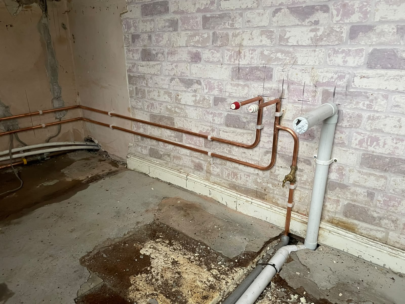 Heating flow and return runs extended along the wall for the relocated radiator