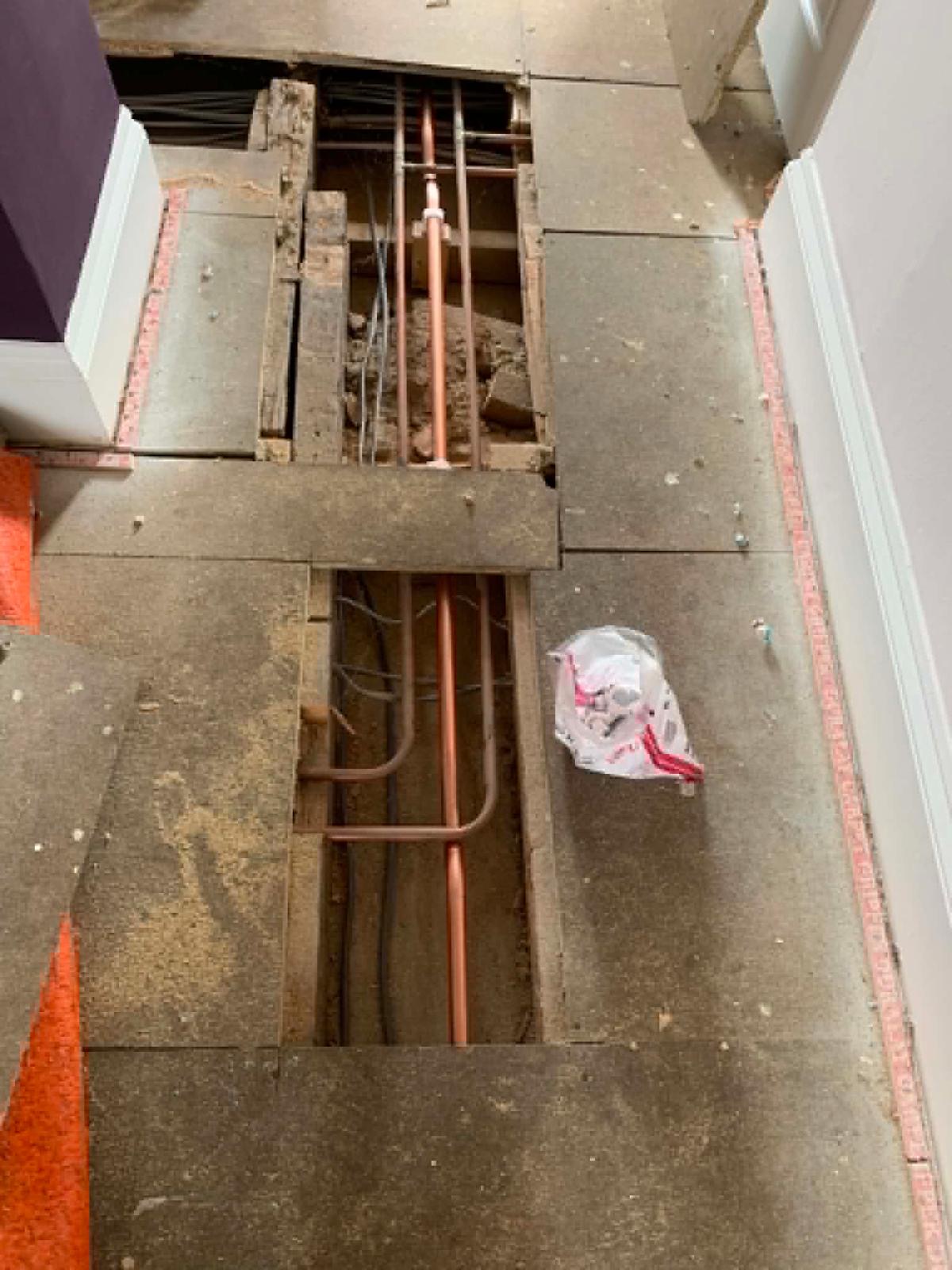 Copper hot water pipes crossing between joists under the bedroom floor