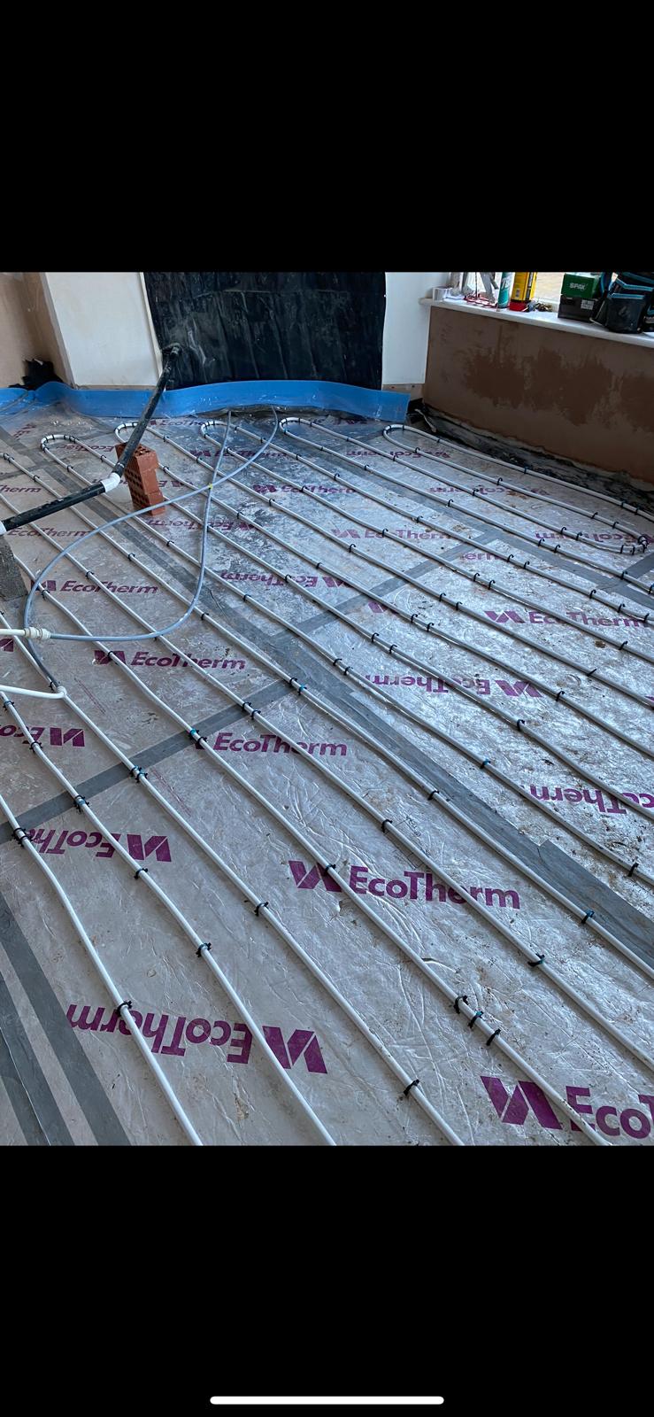 Straight underfloor heating pipe runs clipped at even centres over insulation boards