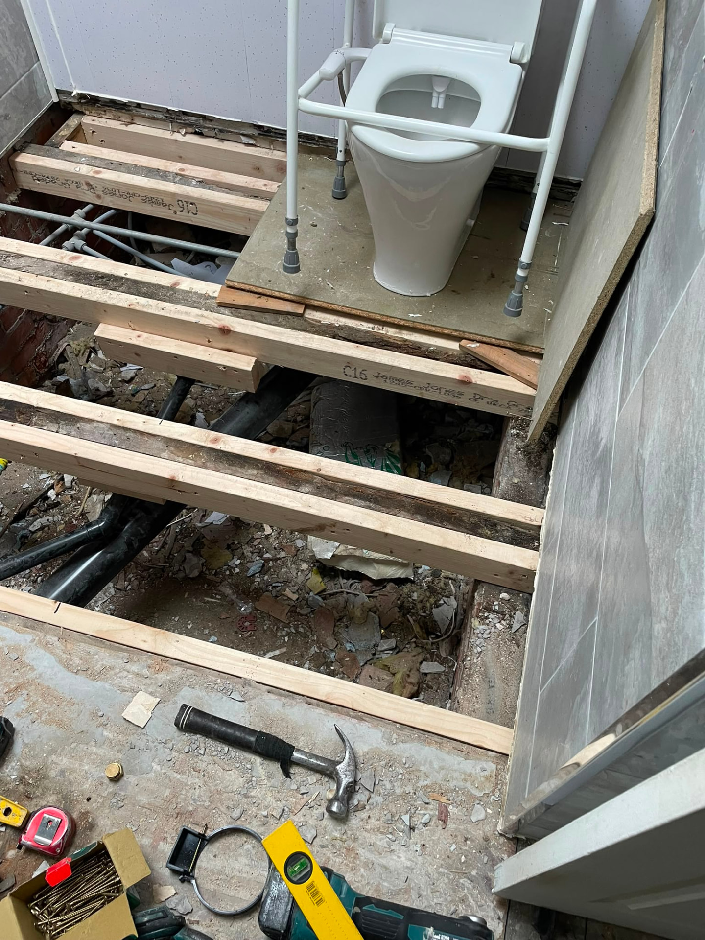 Bathroom floor lifted with WC removed and new waste pipework being run