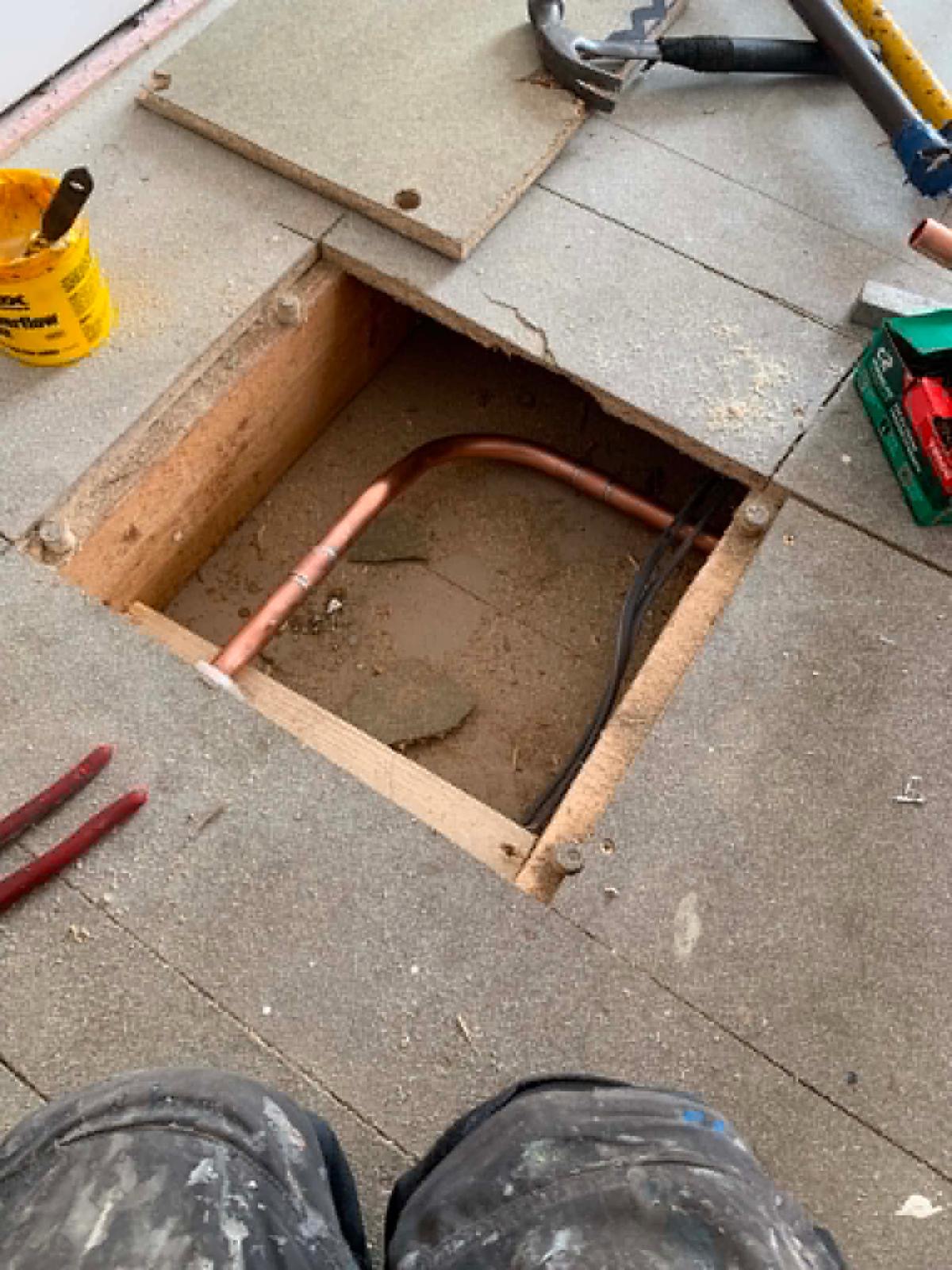 Copper feed bent down through a floor hatch to supply the downstairs taps